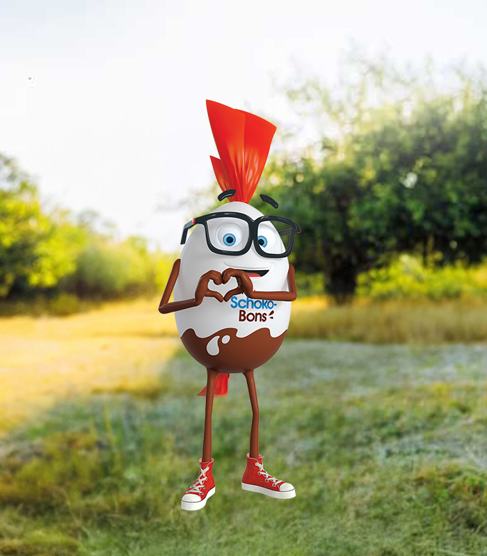 Mr. Bon steht im Gras vor den Bäumen und formt mit seinen Händen ein Herz. 