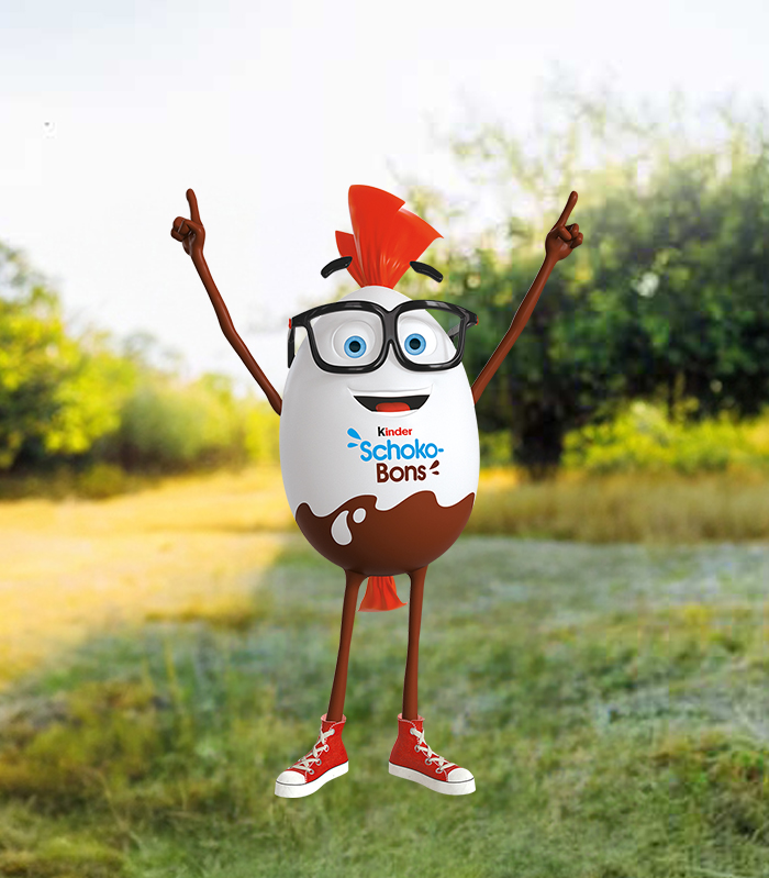 Mr. Bon steht im Gras vor den Bäumen und hält erfreut beide Hände in die Höhe.